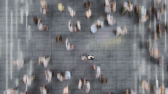 Businessman standing in the fast moving crowds of commuters