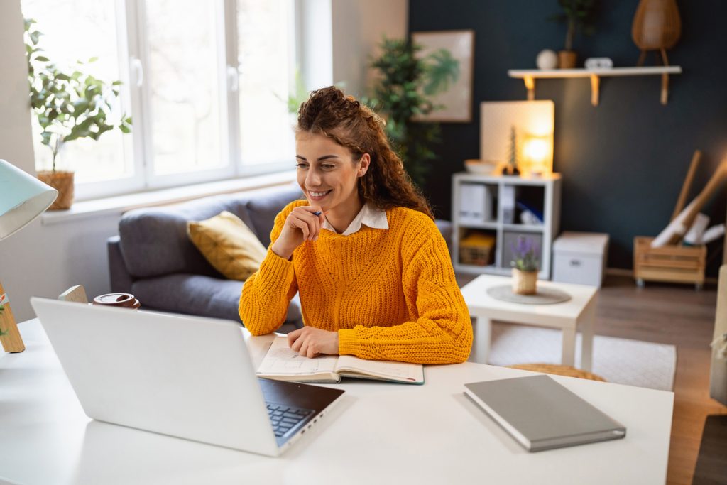 Young Caucasian woman, working on laptop from her modern home office