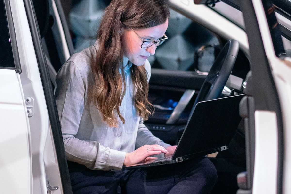 woman sitting in car working on a laptop